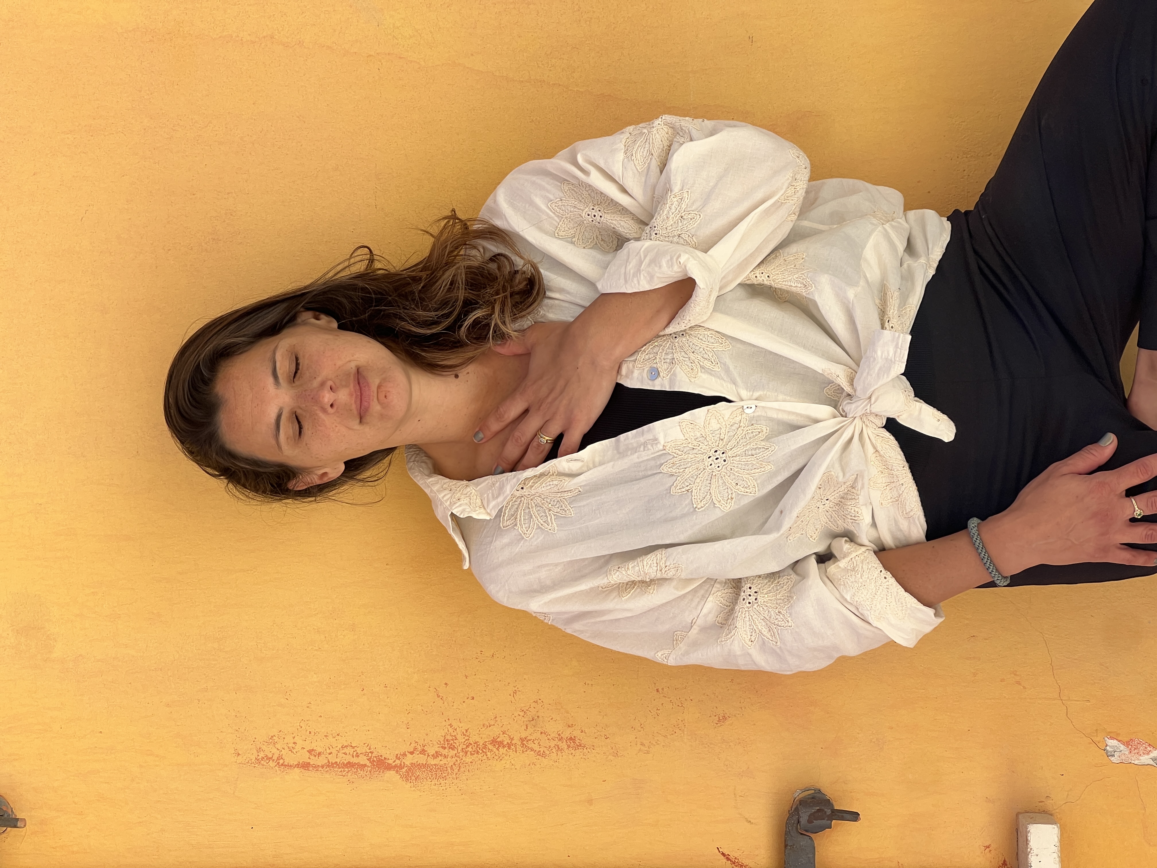 Maya resting with eyes closed against a warm yellow wall